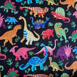 May include: A black background is covered with colorful dinosaur illustrations. The dinosaurs are in various colors, including red, blue, green, and yellow. Some dinosaurs have patterns, and green plant illustrations are scattered throughout.