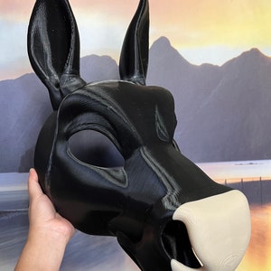 May include: A black and white 3D printed animal mask with large ears. The mask has a detailed snout and a white nose.