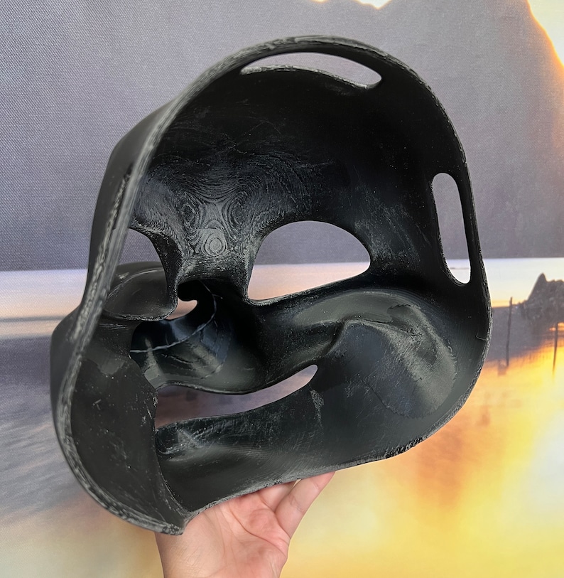 Op de afbeelding: Zwart plastic masker met een getextureerd oppervlak en twee ooggaten. Het masker is ontworpen om de neus en mond te bedekken.