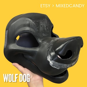 May include: A black wolf dog fursuit head, unpainted, with a textured surface. The head is held in a hand, with the text "WOLF DOG" visible below.