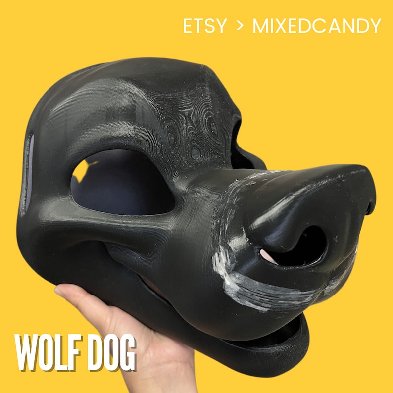 Op de afbeelding: Een ongeschilderde zwarte wolfshond fursuit-kop, met een getextureerd oppervlak. De kop wordt in een hand gehouden, met de tekst "WOLF DOG" eronder.