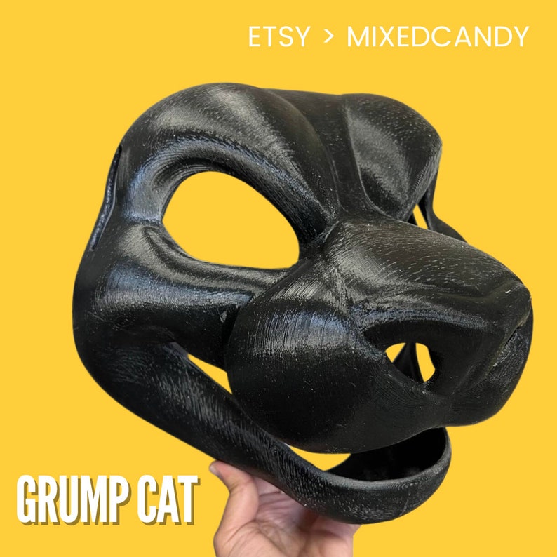 Puede incluir: Una cabeza de fursuit de gato gru&ntilde;&oacute;n negra, impresa en 3D. La cabeza tiene un dise&ntilde;o realista y detallado con una superficie texturizada. Los ojos son huecos y la boca est&aacute; abierta.