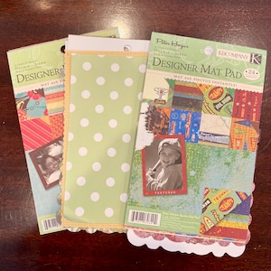 May include: A pack of 24 double-sided 4x6 inch photo mats with a sports theme. The mats feature a variety of colorful designs with words like "champs", "teamwork", and "all star".