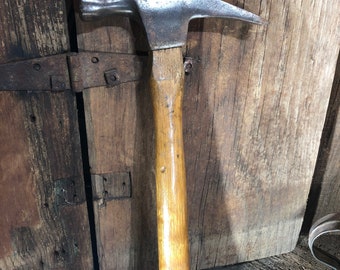 May include: A vintage wooden-handled hammer with a metal head. The hammer has a slightly curved claw and a worn wooden handle.