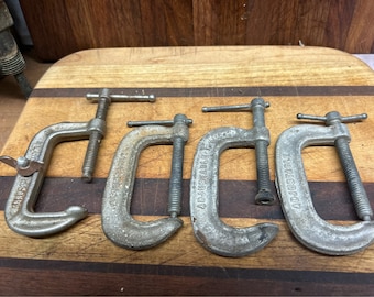 May include: Four silver adjustable clamps with a black handle. The clamps are labeled "ADJUSTABLE" and have a wing nut on the side.