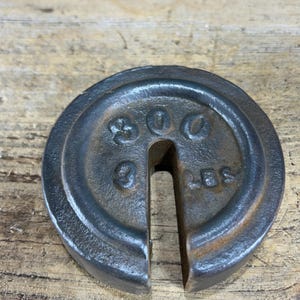 May include: A cast iron weight with a hole in the center. The weight is marked "900 LBS".