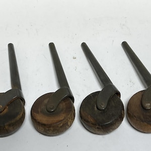 Vintage 4 wood wheel casters, has dings, scratches, rust, working, 2. 7/8“ shafts . wheels are 1 3/4 ” across