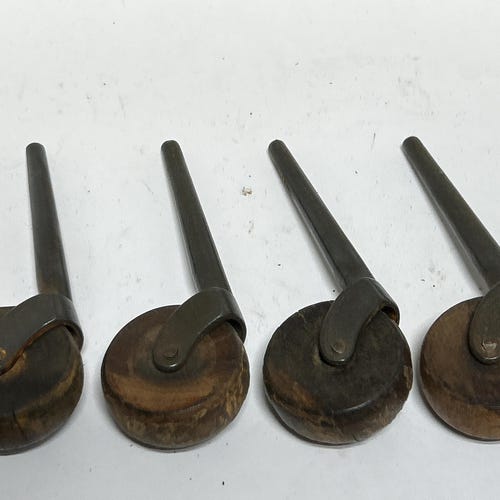 4 roulettes vintage en bois, coups, rayures, rouille, fonctionnement, axes de 2,7/8 po. les roues mesurent 1 3/4 po. de diamètre