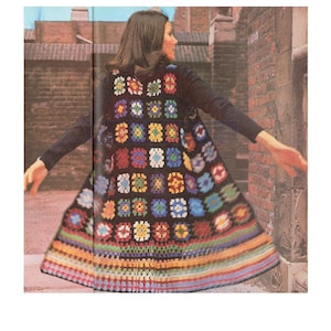 Può includere: Un lungo gilet di uncinetto colorato con sfondo nero e motivo quadrato. Il gilet è realizzato con filati di diversi colori, tra cui rosso, blu, verde, giallo e bianco.