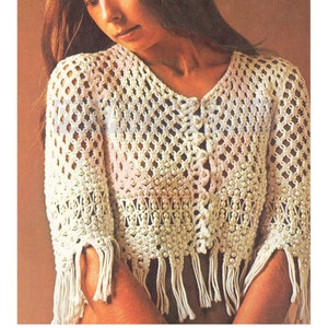 May include: A white crocheted top with a button closure and fringe detailing. The top is made with a delicate open stitch pattern and features a beaded trim.
