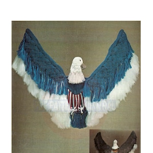 Może przedstawiać: Ręcznie robiony orzeł zrobiony na szydełku w kolorze niebieskim i białym z czerwonymi, białymi i niebieskimi paskami na piersi. Orzeł ma białe pióra wokół głowy i skrzydeł. Orzeł jest patriotycznym projektem rękodzieła.