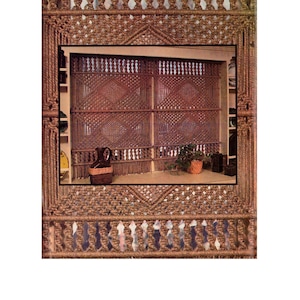 May include: A brown macrame room divider with a diamond pattern. The divider is made of thick rope and has a fringe at the bottom.
