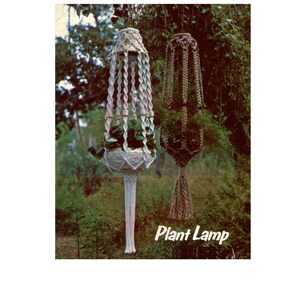 May include: Two macrame plant hangers, one white and one brown, with plants inside. The white hanger has a long, decorative fringe. The image has the text "Plant Lamp" in the bottom right corner. The background is a green, natural setting.