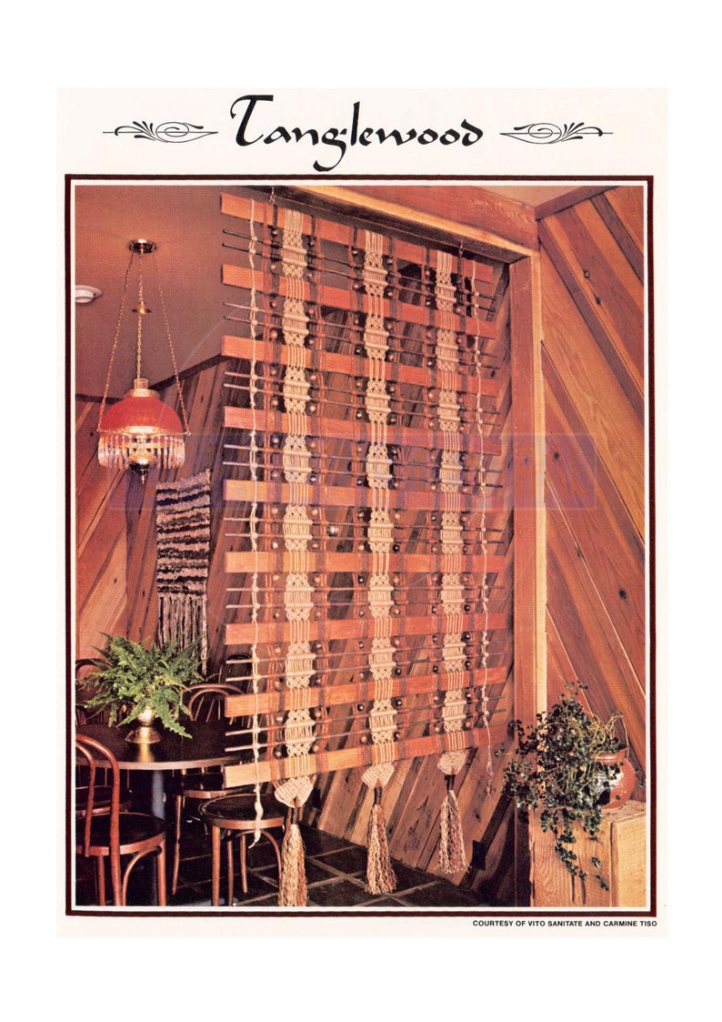 Peut inclure: Une suspension murale en macram&eacute; avec un motif brun et beige, orn&eacute;e de glands et de chevilles en bois. La suspension est pr&eacute;sent&eacute;e dans une pi&egrave;ce avec des lambris en bois et une table en bois avec des chaises.