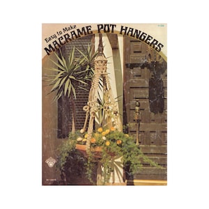 May include: A vintage book cover with a photo of a macrame plant hanger with a potted plant. The book title is "Easy to Make Macrame Pot Hangers" with the number "H-224" in the top right corner.