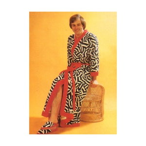 May include: A black and white patterned robe with red trim. The robe is worn by a person sitting on a wicker chair. The person is wearing matching slippers.