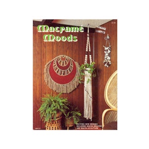 May include: A book titled "Macrame Moods" with a cover image of a macrame wall hanging and a macrame plant hanger. The book features exciting new designs including macra-weaving and macra-sculpture.