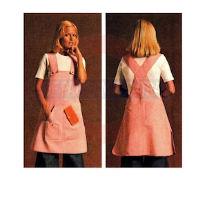 Puede incluir: Un vestido de delantal rosa con una camiseta blanca debajo. El vestido tiene una espalda cruzada y un bolsillo de parche en la parte delantera.