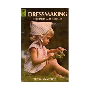May include: A book cover with a photo of a young girl wearing a pink and white dress and a matching hat. The book title is "Dressmaking for Babies and Toddlers" by Teena McKenzie.