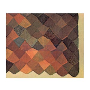 Może przedstawiać: Wełniany koc z geometrycznym wzorem z brązowych, pomarańczowych i zielonych kwadratów. Koc ma falowany brzeg.