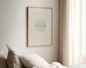 May include: A framed abstract art print featuring a light gray circle bisected by a horizontal line, set against a cream background. The artwork is encased in a light brown wooden frame, creating a minimalist aesthetic. The print hangs on a white wall.