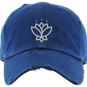 May include: A blue distressed baseball cap with a white embroidered lotus flower design.