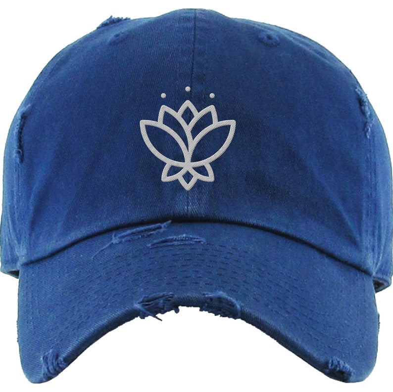 May include: A blue distressed baseball cap with a white embroidered lotus flower design.