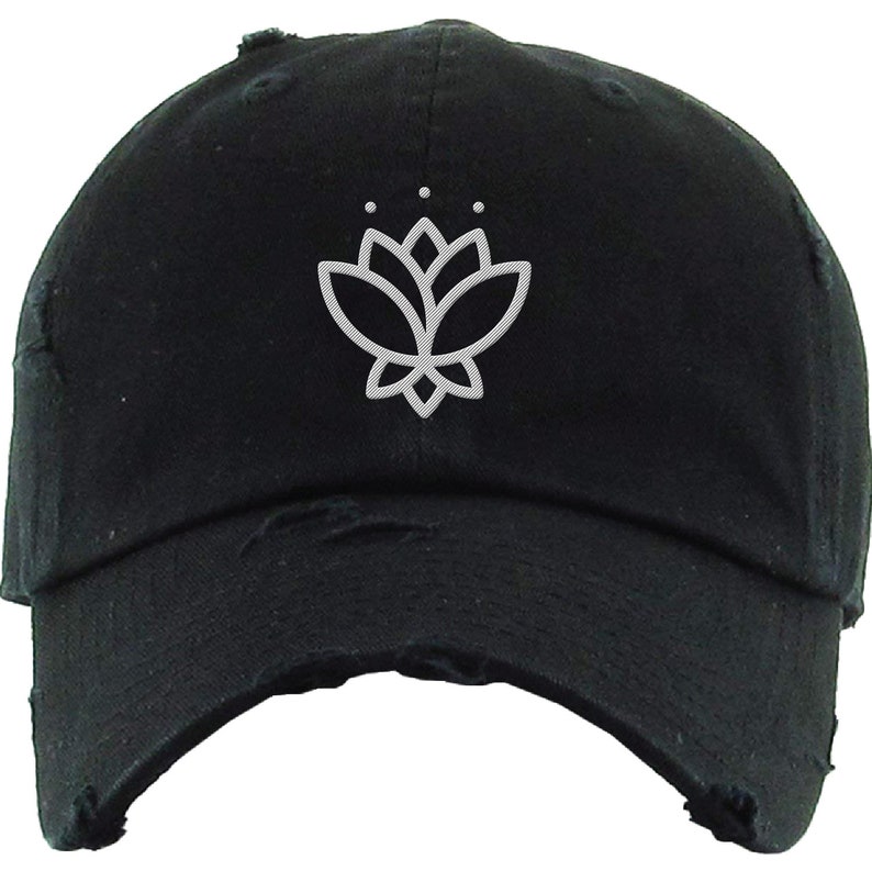 May include: A black distressed baseball cap with a white embroidered lotus flower design.