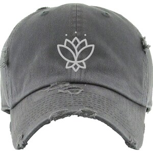 May include: A gray distressed baseball cap with a white outline of a lotus flower on the front.