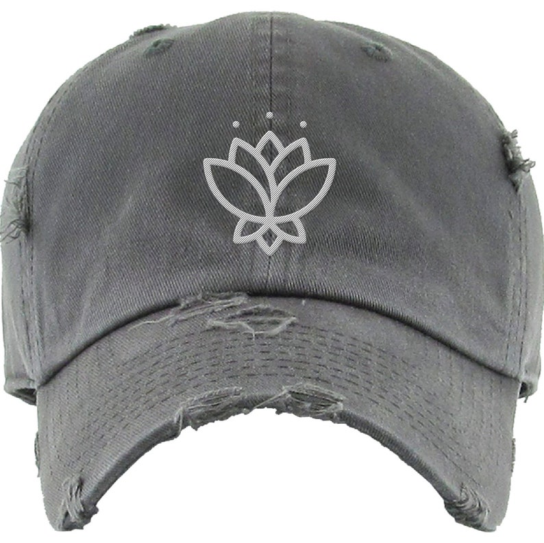 May include: A gray distressed baseball cap with a white outline of a lotus flower on the front.