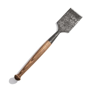 Puede incluir: Un cincel con mango de madera y hoja de metal. La hoja es texturizada y tiene una forma ligeramente curva.