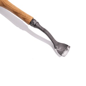 May include: A wooden handled carving tool with a curved metal blade. The blade is sharpened and has a slight curve to it.