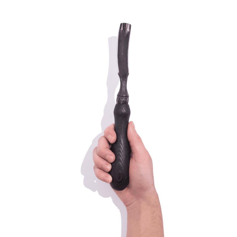 May include: A black wood handled carving tool with a curved blade.