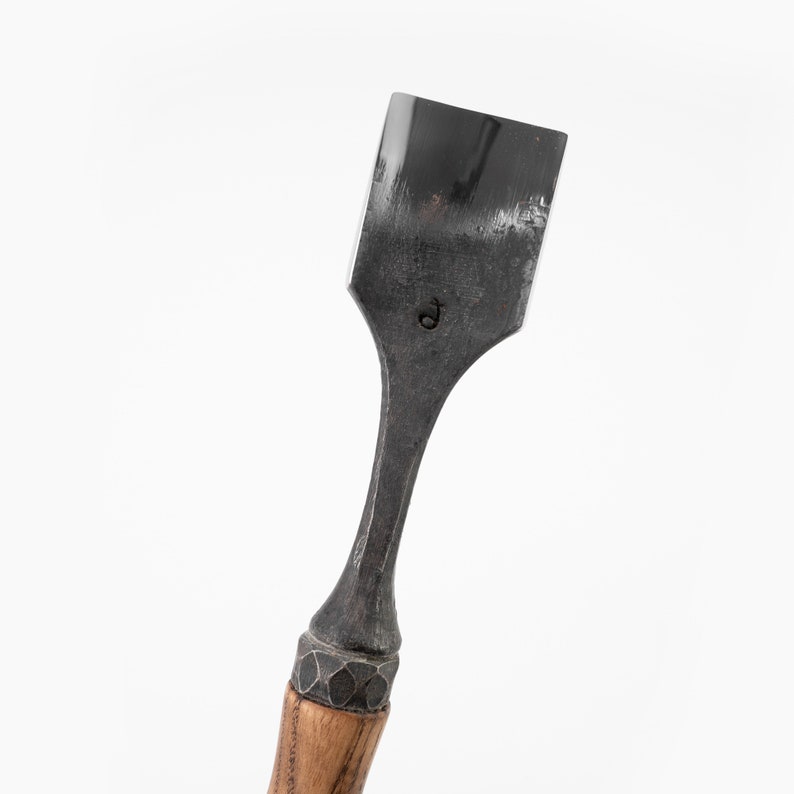 May include: A chisel with a wooden handle and a metal blade. The blade is marked with a "D".