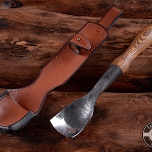 May include: A brown leather sheath with a snap closure and a wooden handled carving tool with a metal blade. The tool has a dark wood handle with a unique grain pattern. The text "Fadir Tools Est. 2016" is visible on the bottom right of the image.