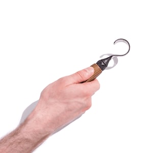 Peut inclure: Un outil de sculpture avec un manche en bois et une lame en métal incurvée. L'outil est tenu dans une main.