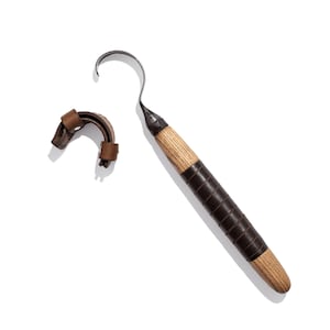 Peut inclure: Un outil à crochet avec un manche en bois et un enroulement en cuir brun. Le crochet est en métal et a une pointe acérée.