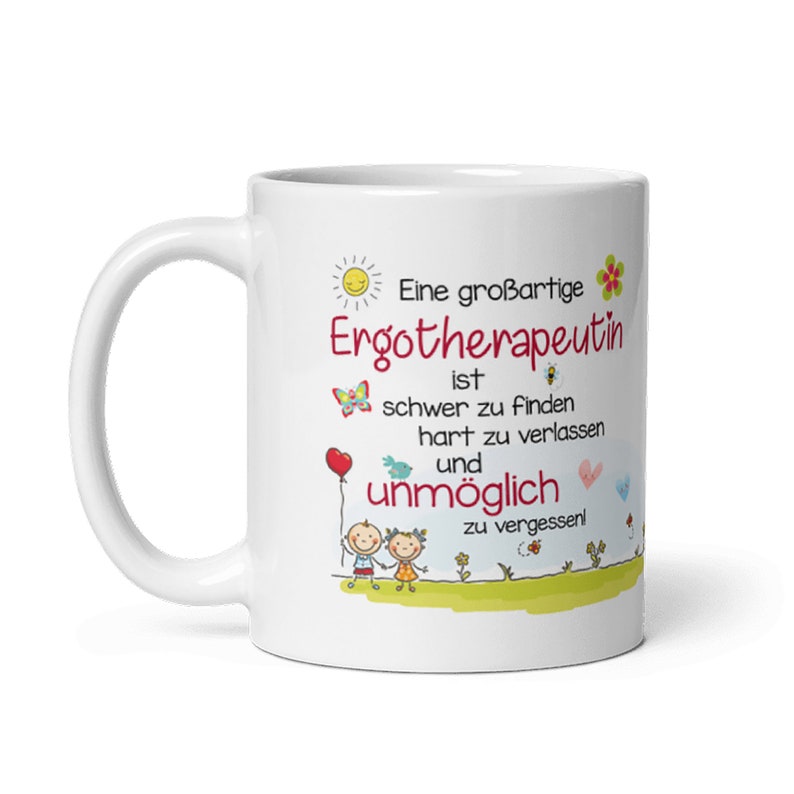 May include: White ceramic coffee mug with a colorful illustration of a smiling sun, butterflies, and two children. The text reads "Eine gro&szlig;artige Ergotherapeutin ist schwer zu finden hart zu verlassen und unm&ouml;glich zu vergessen!"