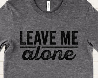 May include: A dark gray t-shirt with the text "LEAVE ME alone" printed in black.