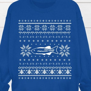 May include: Royal blue sweatshirt with a white, festive pattern. The design includes snowflakes, reindeer, and a central fish graphic. The sweatshirt has long sleeves and a crew neck, perfect for the holiday season.