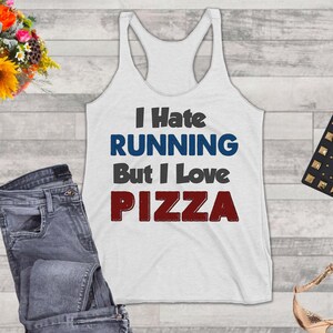 May include: White tank top with the text "I Hate Running But I Love Pizza" in black, blue, and red lettering.