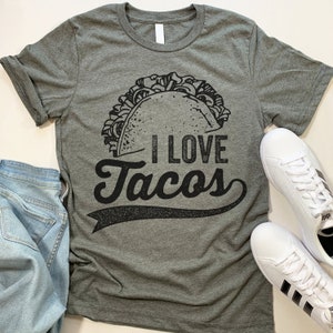 Może przedstawiać: Szary t-shirt z nadrukiem czarnego taco i napisem "Uwielbiam tacosy".
