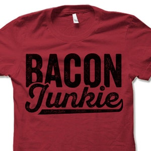 May include: Red t-shirt with black text that reads "BACON Junkie" in a distressed font.