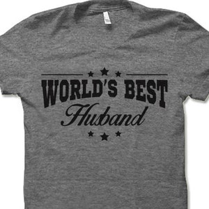 May include: Gray t-shirt with black text that reads "WORLD'S BEST Husband" with stars above and below the text.