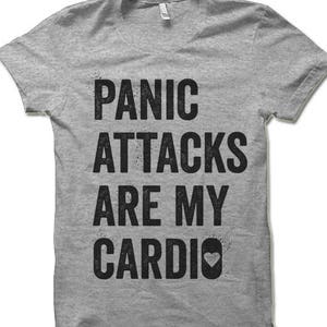May include: A gray t-shirt with the text "Panic Attacks Are My Cardio" in black with a small heart icon.