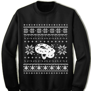 May include: Black Christmas sweater with a white snowflake pattern and a white snake design.
