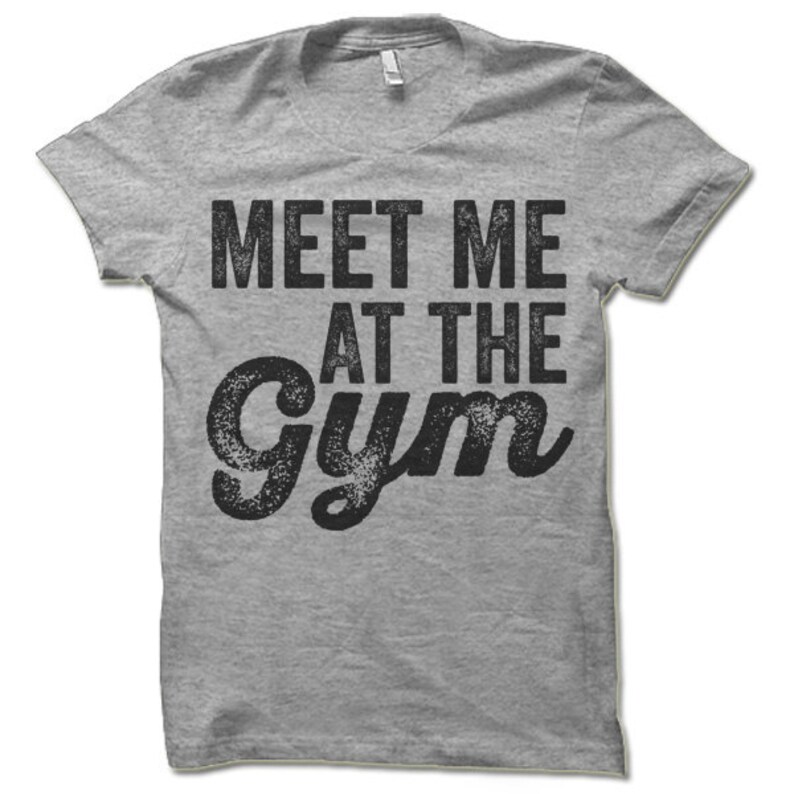May include: Gray t-shirt with the text "Meet Me At The Gym" in black, distressed lettering.