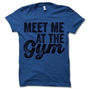 May include: A royal blue t-shirt with the text "Meet Me At The Gym" in a black distressed font.
