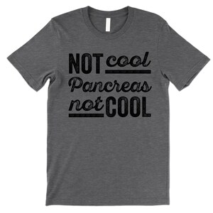 K&ouml;nnte beinhalten: Ein dunkelgraues T-Shirt mit dem Aufdruck "NOT cool Pancreas not COOL" in Schwarz.