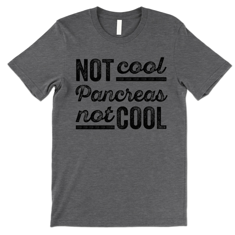 K&ouml;nnte beinhalten: Ein dunkelgraues T-Shirt mit dem Aufdruck "NOT cool Pancreas not COOL" in Schwarz.
